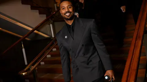 Getty Images Michael B. Jordan con un traje de noche oscuro y broche