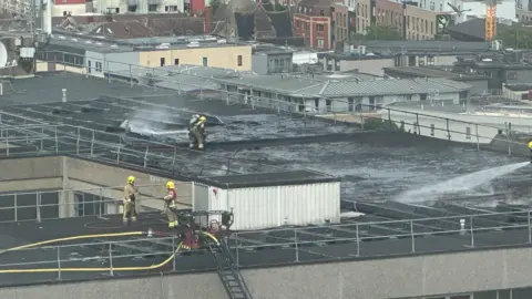 Ewan Woodbridge Firefighters dampening down the roof of St Michael's Hospital where a fire broke out.