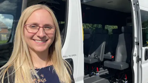 Head Jenni Wright stood next to the new minibus