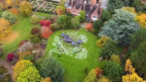 An overhead view showing white markings and blue canopy tents in a grassy field.