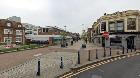 A Google maps image of Biggin Street in Dover. There are some pedestrians on the street. 