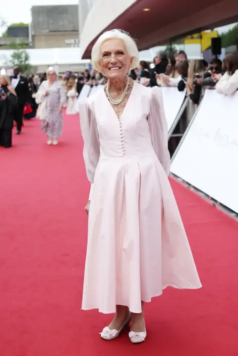 Getty Images Dame Mary Berry smiling and posing in a pink dress