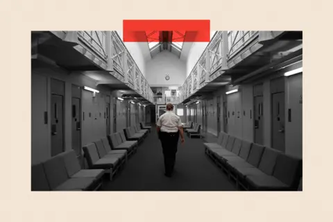 A female prison officer walks down the corridor of the communal area inside HM Prison Styal