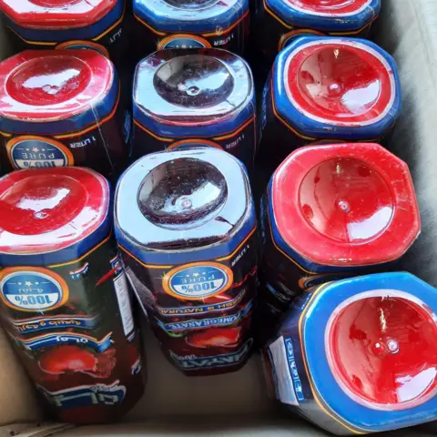 NCA Bottles of pomegranate juice in a cardboard box.