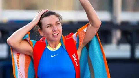 Simona Halep waves to the Miami Open crowd after making her comeback