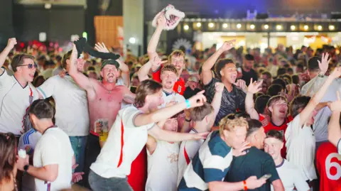 PA Media England fans are jumping and celebrating.