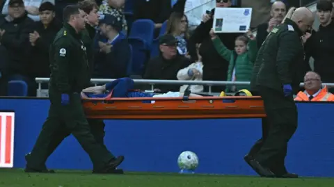 Jarrad Branthwaite covers his face as he is taken off the pitch on a stretcher 
