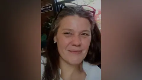 Gerry Smith. Una mujer sonriente con el pelo largo y gafas en la cabeza.