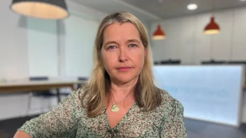 Dr Charlotte Canniff sitting in the reception area of Surrey Heartlands ICB
