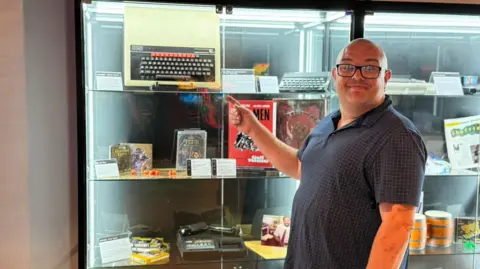 Matthew Bostock stood with the computer he rescued