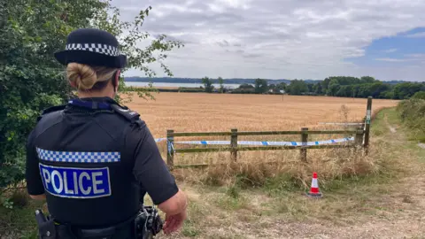 Martin Giles/BBC An officer standing by a police cordon in Brantham following Anita Rose's murder