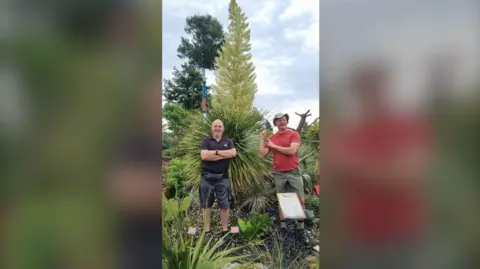 The World Garden Botanist Paul Spracklin (left) and Tom Hart Dyke standing in front of the 12ft Nolina hibernica at The World Garden