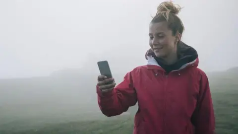 Getty Images Woman trying to get mobile connection