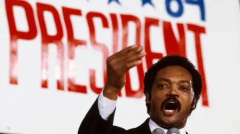 Getty Images Jesse Jackson campaigning in 1984 in front of a large sign which says "president"