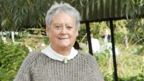 Denise Scott Paulette Crookes stood smiling at the camera at a park 