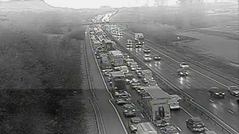 A CCTV image of traffic queuing on one side of the motorway