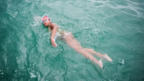 PA Media Prisha Tapre in a swimming costume and crossing the English Channel