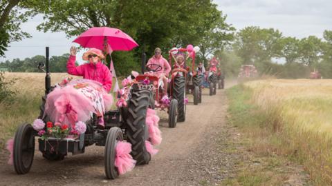 Convoy of pink tractors
