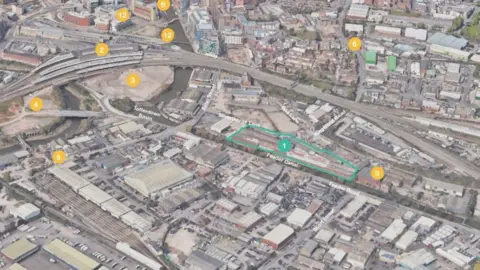 AHMM A 3D map showing the location of the planned apartments. There is a long rectangular shape beside the canal which indicates where the apartments will be built. 