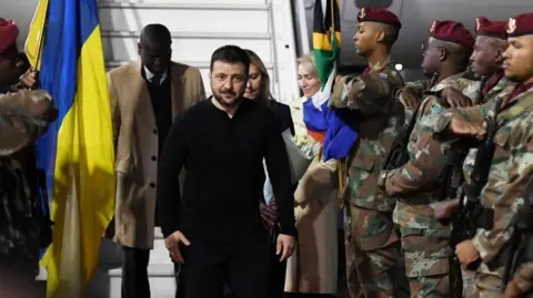 Ukraine's President Volodymyr Zelensky arrive in South Africa. He is greeted by soldiers as he disembarks his plane. 