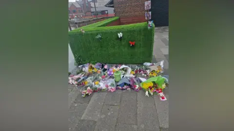 Paul Clarke A memorial with flowers and tributes and photos..
