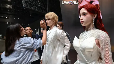 AFP via Getty Images A woman inspects a display showcasing UBTech's lifelike humanoid robots