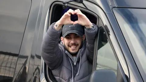 Reuters Image shows Eliya Cohen, a hostage who was held in Gaza since October 7, 2023, putting his hands into the shape of a love heart as he was released from captivity in Petah Tikva, Israel, on 22 February, 2025
