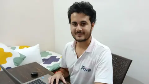 Anurag Garg Anurag Garg is sitting at the computer wearing a white shirt.