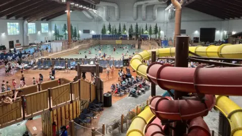Indoor water park with slides, wave pool, and numerous visitors at Great Wolf Lodge Northern California waterpark.