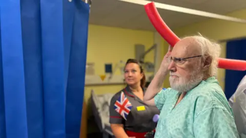 Broomfield Hospital Alan Bass throwing a pool noodle, stood next to Judy Harper-Bright