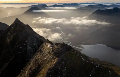 Matt Gibbins An aerial view of An Teallach, a mountain, with clouds swirling around it 