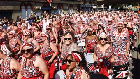 Reutterer Group in a red-colored group of color, black and white, opening packs during the parade. 