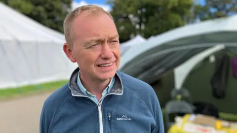 A man with ginger hair and a blue fleece.