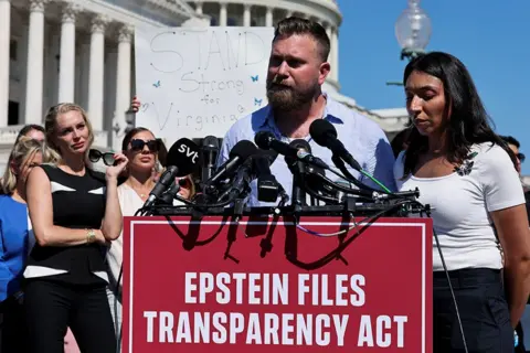 Reuters Virginia Giuffre's family stand in front of several microphones, campaigning for the release of information about Jeffrey Epstein