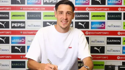 Keven Schlotterbeck signing the contract at Southampton.