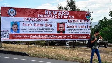 Getty Images A man walks past a banner offering rewards for information leading to the arrest of Venezuelan President Nicolás Maduro and Interior Minister Diosdado Cabello in Villa del Rosario, Norte de Santander, Colombia.