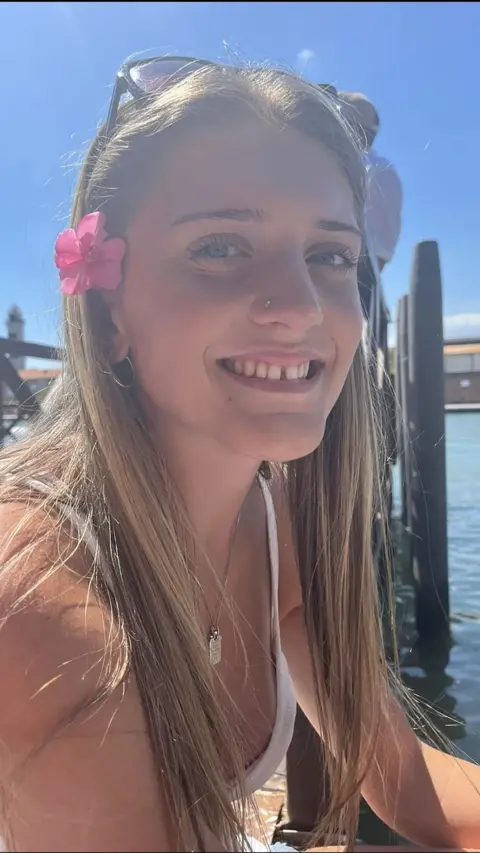 A young girl smiling towards the camera