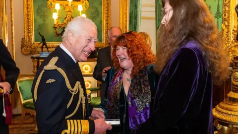 PA Bex Lombard receiving the Elizabeth Emblem from the King