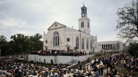 Getty Images A large crowd of people sat on seats around the rebuilt St Mary Aldermanbury in Fulton, Missouri, for the rededication ceremony in 1969