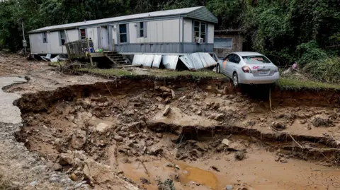 Mobilheim und Fahrzeug der Environmental Protection Agency (EPA) entlang des Swannanoa River nach der katastrophalen Überschwemmung durch Sturm Helen