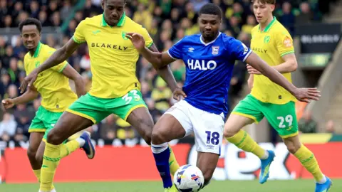 Nigel French/PA Media Ben Johnson is about to kick the ball with Jose Cordoba behind him poised to tackle