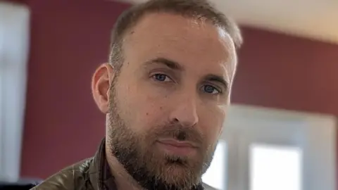 Luke Valle, a close-up image of Luke Vale, owner of Hamilton Smith. He is looking at the camera and trapped light brown hair and beard. 