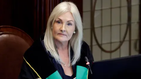 PA Media A woman with blonde hair wearing a green and black top