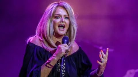 Bonnie Tyler singing into the microphone