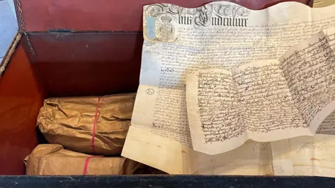 An open chest filled with historical documents