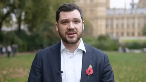 Henry Zeffman outside parliament wearing a suit and poppy pin