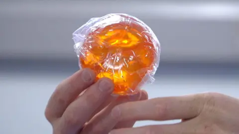 A NeeDoh squishy nice cube in a hand.