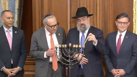 From left, Hakeem Jeffries, Chuck Schumer and Mike Johnson during the Menorah lighting ceremony.