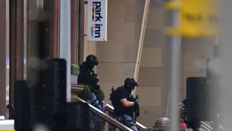 Getty Images Armed officers leaving the Park Inn in Glasgow in June 2020. The officers are wearing helmets, protective clothing and carrying guns. 