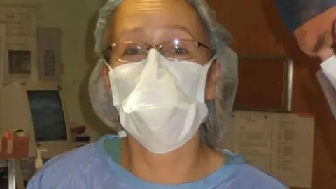 Rachael Hutchinson Orthopaedic surgeon Rachael Hutchinson in blue theatre scrubs and a mask
